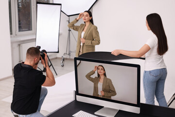 Poster - Professional photographer and assistant working with beautiful model in modern photo studio, selective focus