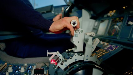 Wall Mural - Close-up of a pilot's hand pressing the throttle in the cockpit of a jet plane reducing engine power