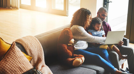 Mom, dad and kid with laptop on sofa for website, internet and subscription for educational media in family home. Parents, child and watching movie on computer for online streaming, elearning and fun