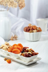 Sticker - Dried fruits and assorted nuts on a white table.