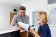 © Graphicroyalty - Man making an appointment with medical staffs at reception desk in hospital. Medical staff and nurse - receptionist talking to patient in front of the reception counter in hospital.