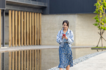 Wall Mural - Woman walk in the street with her phone