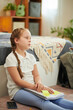 © DragonImages - Girl tired after doing homework sitting on floor in her bedroom