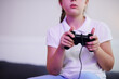 © DragonImages - Cropped image of girl enjoying playing new video game at home