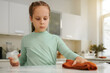 © DragonImages - Serious girl spraying detergent and wiping kitchen counter with soft cloth