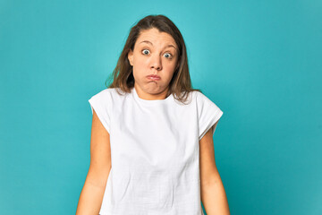 A young caucasian woman isolated shrugs shoulders and open eyes confused.