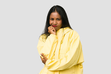 Wall Mural - Young Indian woman cut out isolated on white background biting fingernails, nervous and very anxious.