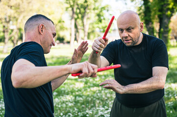 Wall Mural - Knife vs knife fight combat training. Sumbrada training method. Plastic weapon defend demonstration drill