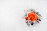 Gemstones for esoteric spiritual practice. Reiki therapy concept. Feng Shui, Healing Crystal Ritual, Witchcraft, Relax Chakra, litho therapy. Crystals with flower ranunculus on white table.