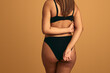 © kegfire - Crop plump woman in underwear on beige background