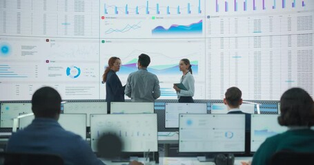 Wall Mural - Wide Back Shot of Diverse Team of Data Scientists Discussing Graphs And Reports On Big Digital Screen In Monitoring Office. Multiethnic Employees Working On Desktop Computers For Deep Learning Company