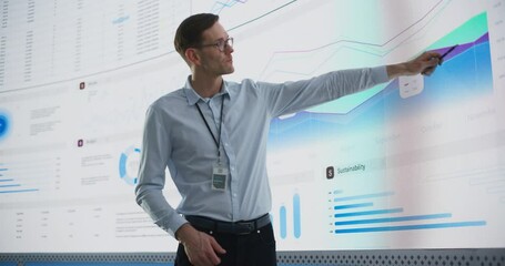 Fototapete - Male CEO Of Data Science Company Is Giving Presentation In Front Of Big Digital Screen With Graphs And Charts. Successful Caucasian Man Reviewing Business Accomplishments And Objectives In the Office.