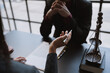 © crizzystudio - Young businessman concentrating on signing a contract with a skilled female lawyer and financial adviser explaining in detail legal information for signing a contract at a meeting in an office.