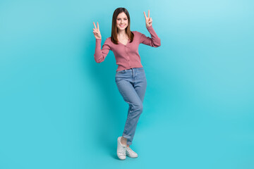 Wall Mural - Full length photo of happy smiling woman wear pink shirt denim jeans shopping show fingers double v-sign isolated on cyan color background