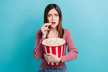 Poster - Photo of adorable impressed girl straight hairdo dressed pink cardigan holding popcorn watching thriller isolated on blue color background