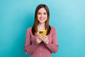 Wall Mural - Photo of cheerful good mood girl with straight hairdo dressed pink cardigan holding smartphone read post isolated on blue color background