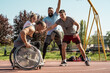 © BalanceFormCreative - A physically challenged man in a wheelchair fearlessly engages in a spirited game of basketball with his supportive friends, breaking barriers and proving that passion and teamwork know no bounds.