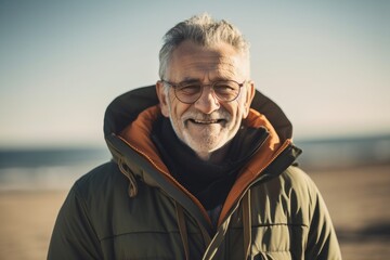 Poster - Portrait of a senior man in winter jacket on the beach.