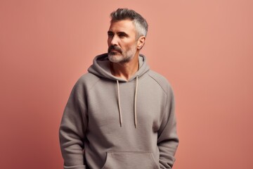 Wall Mural - Portrait of a man in a gray hoodie on a pink background