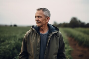 Wall Mural - Portrait of mature farmer standing in field. Man looking at camera.