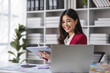 © wichayada - Young woman working on a laptop in the office. Asian businesswoman sitting at her workplace in the office. Beautiful Freelancer Woman working online at her home.