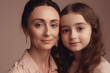 © Lazy_Bear - Cheerful woman and young girl looking at camera. Mother and daughter portrait on pink background. Good relationship between mom and child in the family. Created with Generative AI
