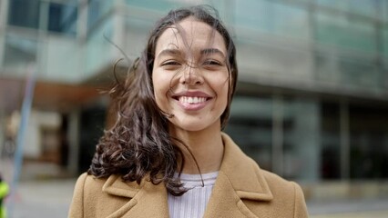 Wall Mural - Young beautiful hispanic woman smiling confident at street