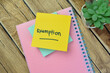 Concept of Exemption write on sticky notes isolated on Wooden Table.