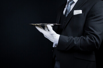 Wall Mural - Portrait of Elegant Butler or Waiter in Dark Suit and White Gloves Holding Silver Service Tray.