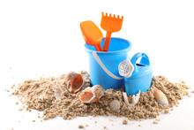 Toy Bucket And Shovel With Sand And Seashells Isolated On White Background