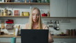 © stockbusters - Woman working remotely kitchen with laptop closeup. Girl have online job.