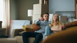 © stockbusters - Man giving keys woman from new house. Happy couple sitting on comfortable couch.