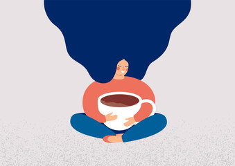 young woman embraces a big cup of coffee with enjoyment. smiling girl sits in lotus pose with closed