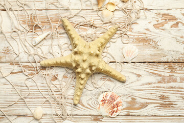 Wall Mural - Beautiful starfish with seashells and net on light wooden background