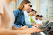 © JackF - Woman sitting in classroom during lecture in university and using laptop.