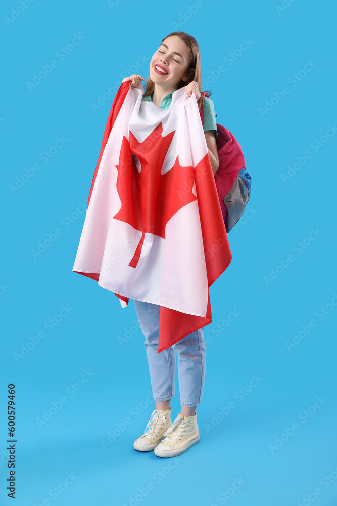 Young woman with flag of Canada on blue background
