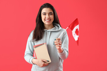 Canvas Print - Young woman with flag of Canada and books on red background