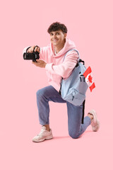 Poster - Young man with photo camera, backpack and flag of Canada on pink background