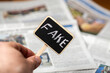 Fake news concept. Sign with the inscription fake on the background of the newspaper.