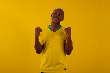 Wall Mural - Black-skinned Brazilian man with Brazilian soccer team shirt in studio photo