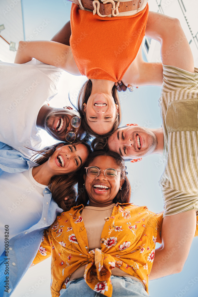 Vertical low view angle of a group of multiracial teenagers smiling and ...