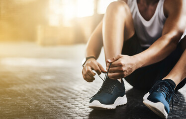  Fitness, gym and man tie shoes before a workout for health, wellness and endurance training. Sports, healthy and closeup of male athlete preparing while tying laces before a exercise in sport center.