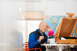 © Cavan Images - Senior retiree painting in the afternoon