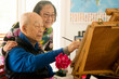 © Cavan Images - Senior retiree painting in the afternoon