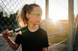 © Cavan Images - Girl holding a innebandy stick waiting to play a game at sunset