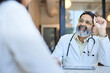 © Cavan Images - Happy male doctor wearing eyeglasses looking at female patient