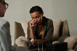 © pressmaster - Young upset African American woman wiping her tears while crying during psychological session in front of female counselor listening to her