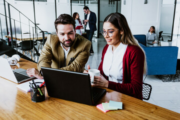 young latin couple woman and man working and using laptop at office in Mexico, hispanic teamwork in Latin America