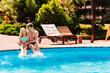 © andrey - Dad and daughter have fun and and sit on the edge of the pool