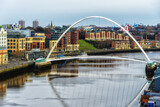 Gateshead Millennium Bridge crossing River Tyne in Gateshead, with a view of Newcastle upon Tyne, UK